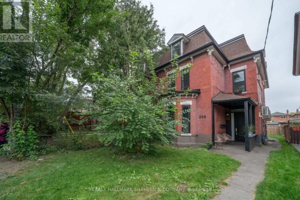 Side view of a red brick house with a covered porch and walkway. - Bachelor - 208 Dovercourt Road, Toronto