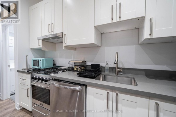 A compact kitchen with white cabinets, stainless steel appliances, and a gas stove. - Bachelor - 208 Dovercourt Road, Toronto