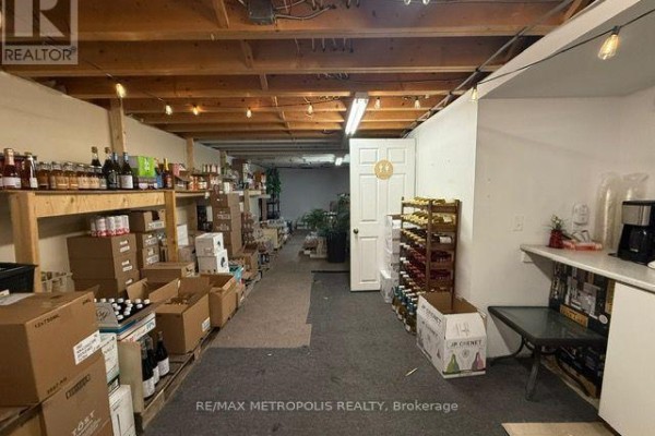 Basement level with shelves of products, boxes, and wine racks. - Back - 15 Dunlop Street W, Barrie