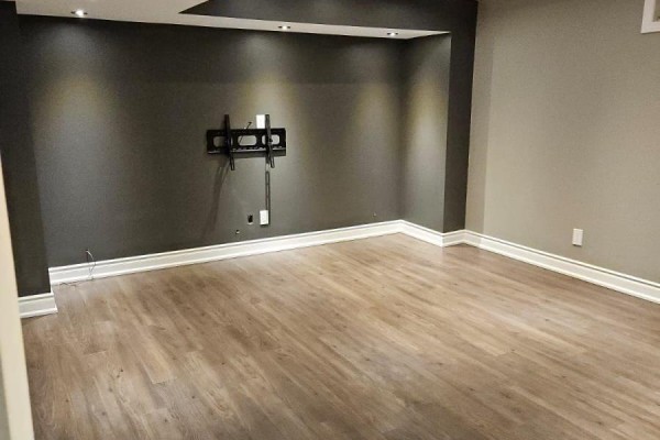 Empty basement room with a wall-mounted TV bracket and neutral grey walls. - Basement - 118 Earlsbridge Boulevard, Brampton
