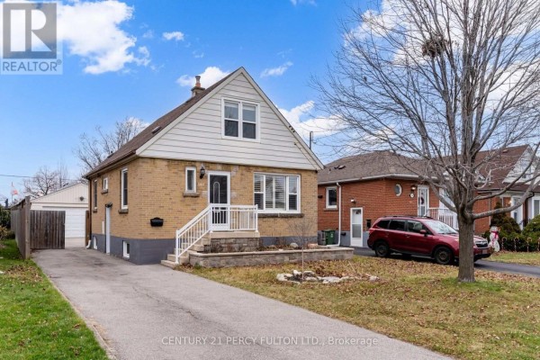 Side view of a light brown brick house with a garage and a paved driveway. - Basement - 144 Taylor Avenue, Hamilton
