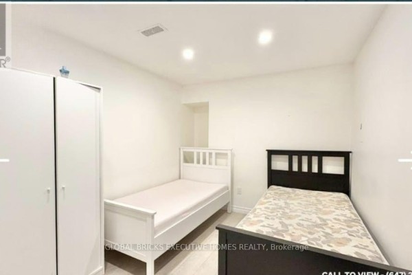 Two single beds and a white wardrobe in a room with white walls and light-colored flooring. - Basement - 1761 Mcgill Court, Oshawa