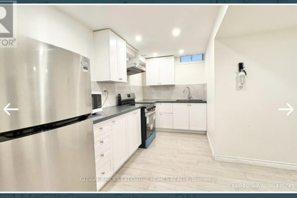 Close-up of a kitchen with white cabinets, a stainless steel stove, and a microwave. - Basement - 1761 Mcgill Court, Oshawa