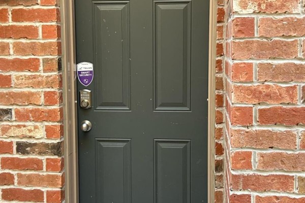 Close-up of the front door with a security system and brick wall. - Basement - 18 Elderslie Crescent, Vaughan