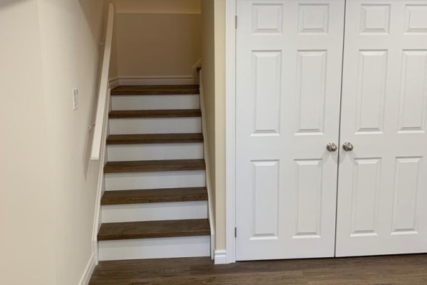 Stairs leading up with white closet doors and laminate flooring. - Basement - 18 Elderslie Crescent, Vaughan