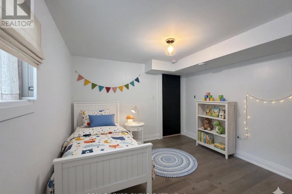 Child's bedroom featuring a single bed, bookshelf, and decorative bunting. - Basement - 184 Ottawa Street S, Hamilton
