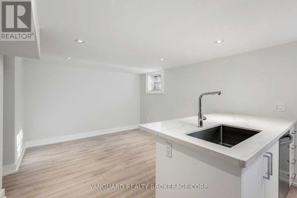 View of a basement kitchen area with an island and a small window. - Basement - 187 Brooke Avenue, Toronto