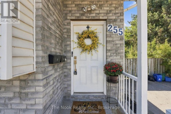 Close-up of the front entrance with a white door, wreath, mailboxes, and potted plant. - Basement - 255 Greenwood Avenue, Oshawa