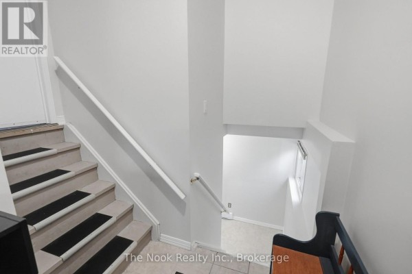 View looking down a staircase with beige carpeted steps and white railings. - Basement - 255 Greenwood Avenue, Oshawa
