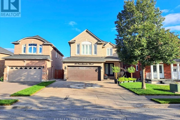 Front exterior of a light brick house with a double garage, paved driveway, and green lawn. - Basement - 26 Smoothwater Street, Brampton