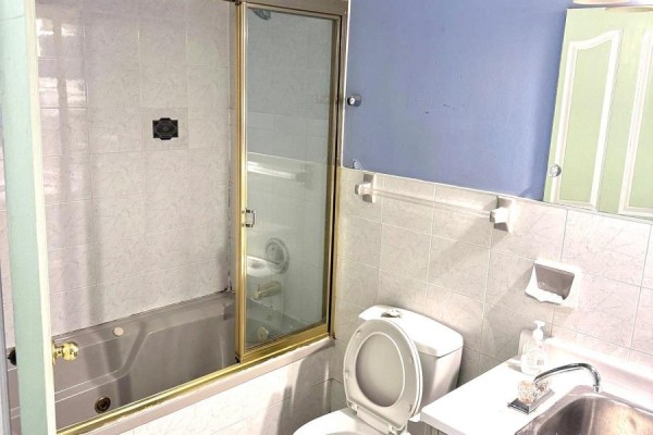 Basement bathroom with a bathtub, shower, toilet, sink, and light blue and white tiled walls. - Basement - 3 Blairville Road, Toronto