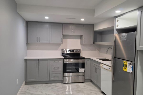 L-shaped basement kitchen with light grey cabinets, white countertops, and stainless steel appliances. - Basement - 63 English Drive E, New Tecumseth