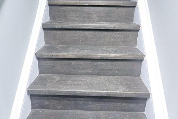 Close-up of a wooden staircase with gray treads and white risers. - Basement - 68 Hyacinth Crescent, Toronto