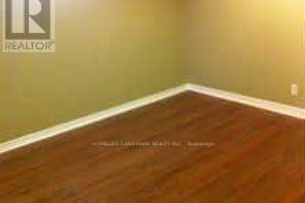View of a basement room's corner with wooden floors and green painted walls. - Basement - 7080 Estoril Road, Mississauga