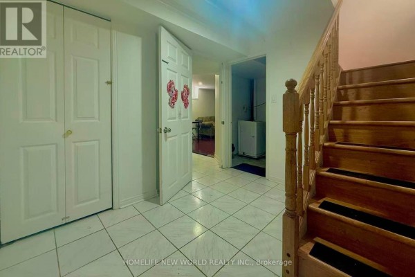 Basement hallway with white tiled floor, double door closet, and wooden staircase. - Basement - 84 James Edward Drive, Markham