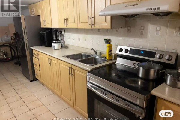 Kitchen with light wood cabinets, stainless steel appliances, double sink, and stove. - Basement - 91 Markham Street, Toronto
