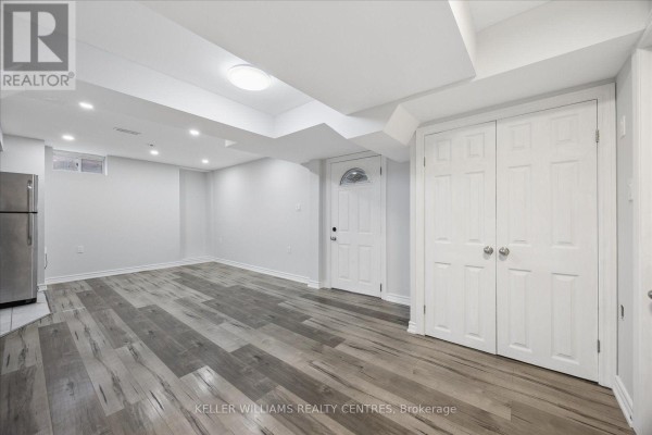 Bright, open basement living area with grey wood-look flooring and white walls. - Basement 1 - 277 Gibson Circle, Bradford West Gwillimbury