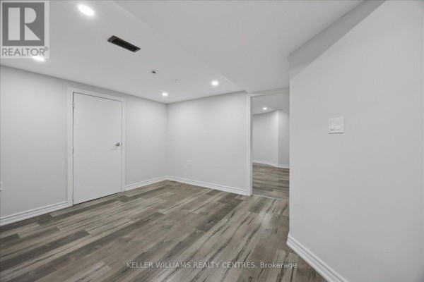 Entrance to the basement with a white door and doorway leading to a kitchen. - Basement 2 - 277 Gibson Circle, Bradford West Gwillimbury