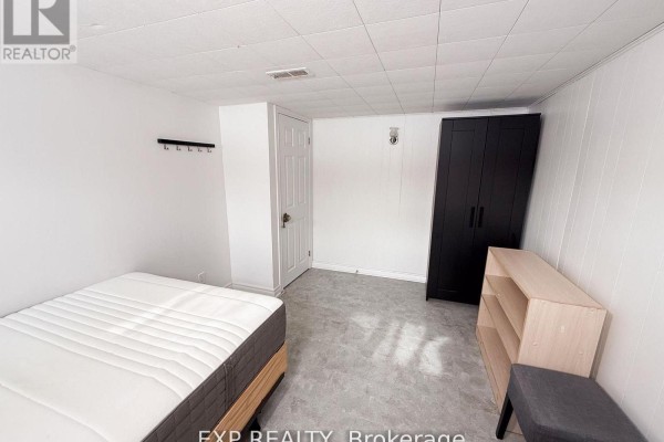Bathroom with shower, toilet, and sink, featuring tiled walls. - Basement Room 3 - 500 Drewry Avenue, Toronto