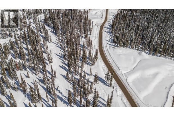 Aerial view of a paved road winding through a snow-covered forest. - Black Forest Way Lot# 5, Big White