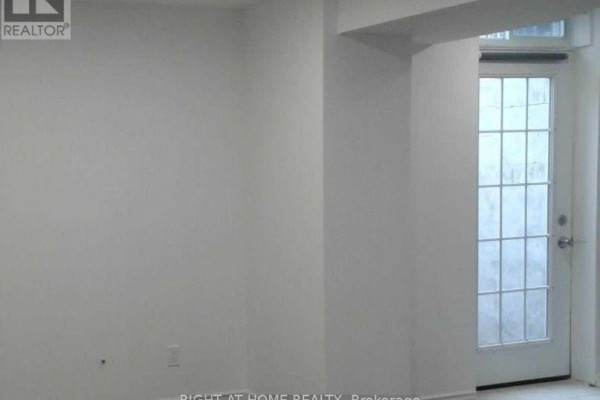 Interior view of a white-walled room with a large frosted glass door leading outside. - Bsmet - 75 Maffey Crescent, Richmond Hill