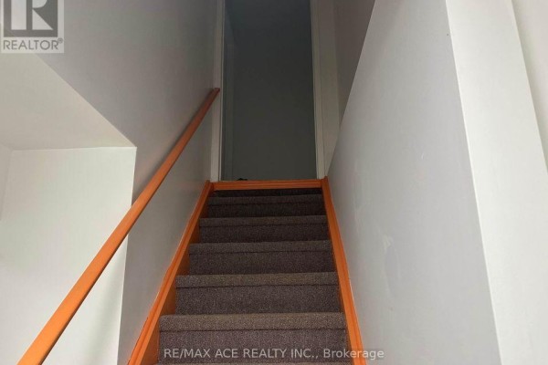 Carpeted staircase with orange handrail leading down into basement. - Bsmt - 11 Seasons Drive, Toronto