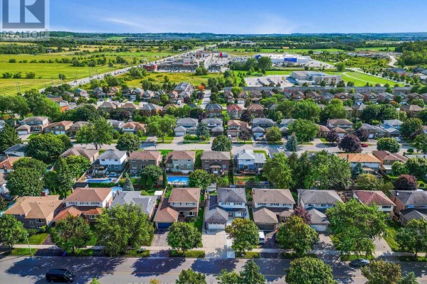 Aerial view of a suburban neighbourhood with houses, green spaces and distant commercial buildings. - Bsmnt - 201 Biscayne Boulevard, Georgina