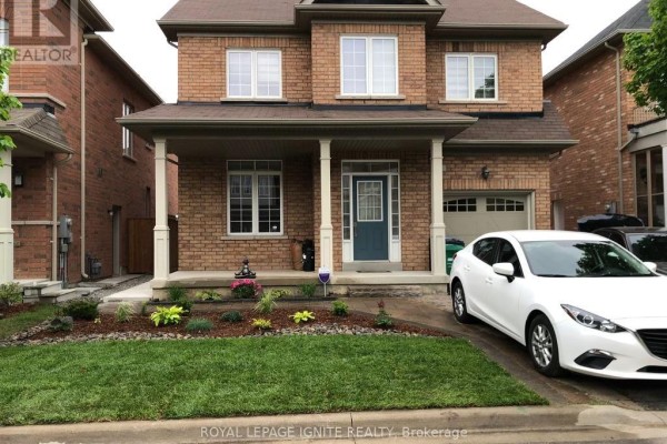 Close-up of the front porch with landscaping and parked vehicles - Bsmnt - 33 George Robinson Drive, Brampton