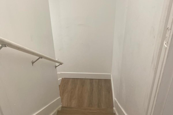 View looking down a short staircase with white walls and a handrail to a wood-look floor. - Bsmnt - 684 Fenwick Way, Ottawa