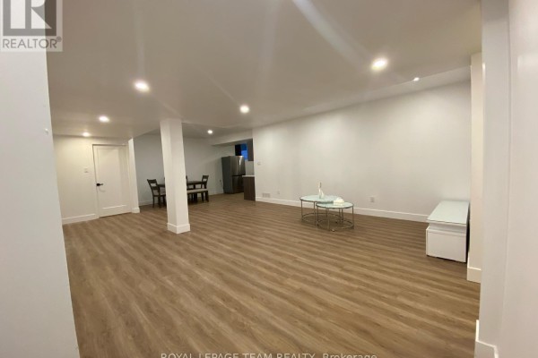 Open concept basement living area with white walls, recessed lighting, and wood-look flooring. - Bsmnt - 684 Fenwick Way, Ottawa