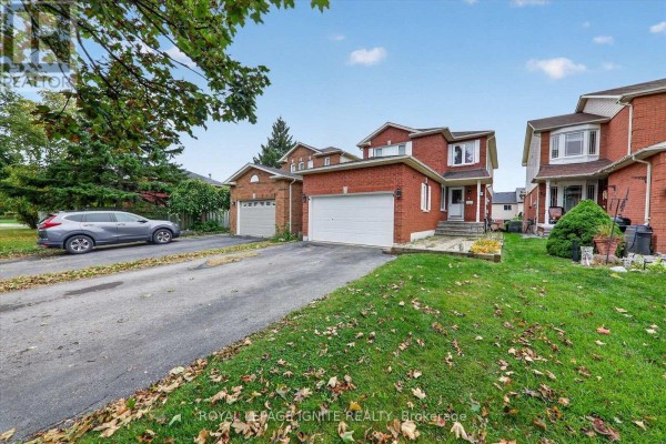 Side exterior view of a two-story brick house with a garage and a car parked in the driveway. - Bsmnt - 8 Vail Meadows Crescent, Clarington
