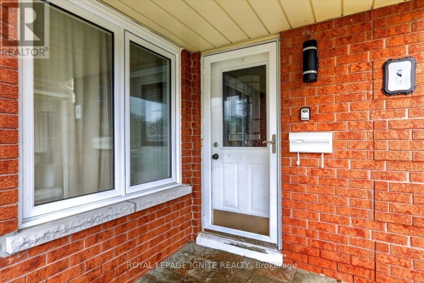 Close-up of a front door with a window, mailbox, and black exterior light on brick wall. - Bsmnt - 8 Vail Meadows Crescent, Clarington