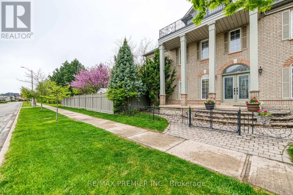 Sidewalk and green lawn in front of a large brick house with columns. - Bsmt - 1 Johnswood Crescent, Vaughan
