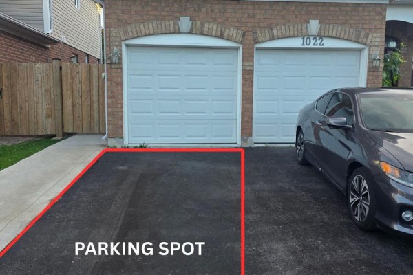 Driveway with a car and a red outlined parking spot next to a double garage. - Bsmt - 1022 Glenbourne Drive, Oshawa