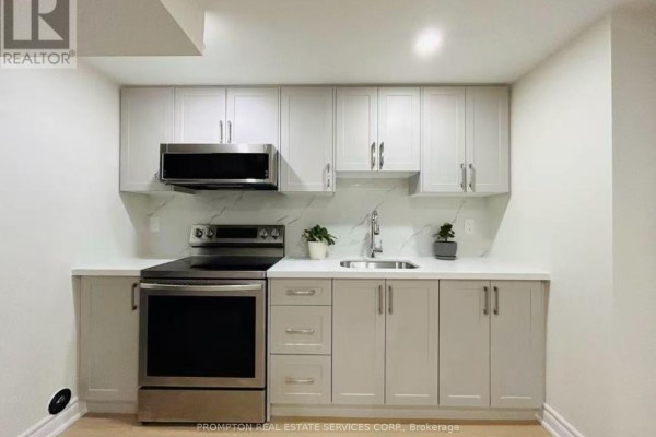 A basement kitchen with light grey and white cabinets, stainless steel appliances, and a quartz countertop. - Bsmt - 1443 Cooper Court, Oakville