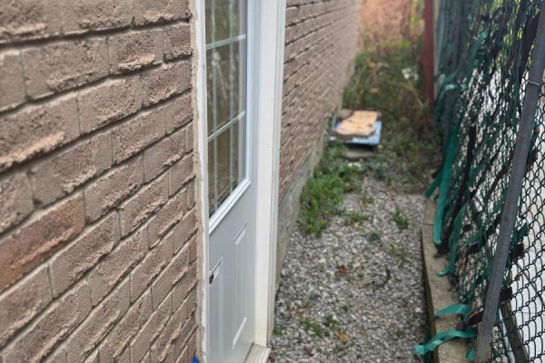 Close-up of side door and brick exterior wall with gravel pathway. - Bsmt - 147 Morton Way, Brampton