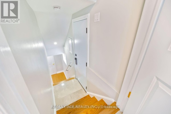 View looking down a narrow staircase with white walls and wooden treads. - Bsmt - 15 Cree Avenue, Toronto