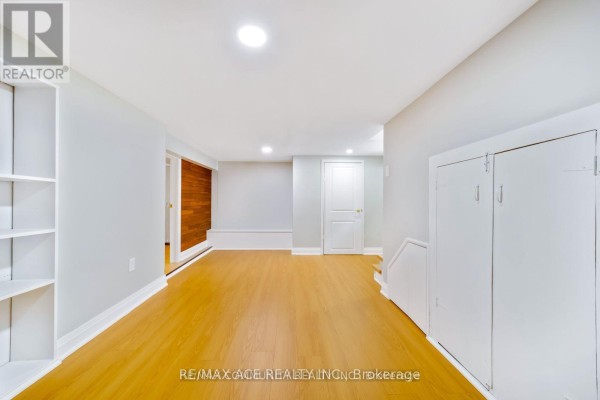 Spacious unfinished basement area with light wood laminate flooring and white walls. - Bsmt - 15 Cree Avenue, Toronto