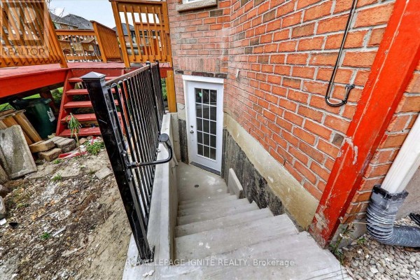 Exterior basement entrance with concrete stairs, metal railing, and a basement door. - Bsmt - 15 Starry Crescent, Toronto