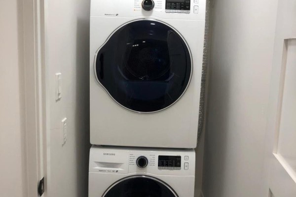 Stackable white Samsung washer and dryer unit in a narrow closet space. - Bsmt - 154 Delhi Avenue, Toronto