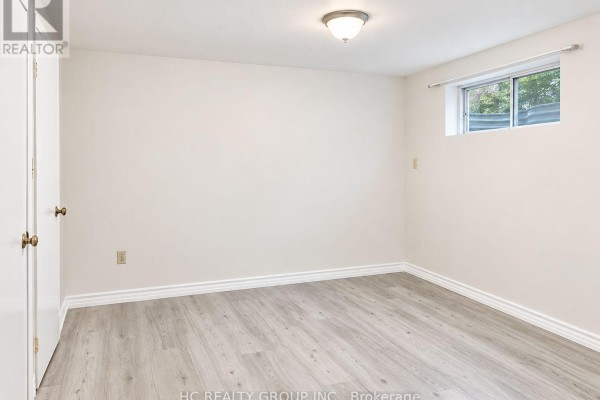 Basement bedroom with white walls, laminate flooring, and a small window with metal blinds. - Bsmt - 156 Major Buttons Drive, Markham