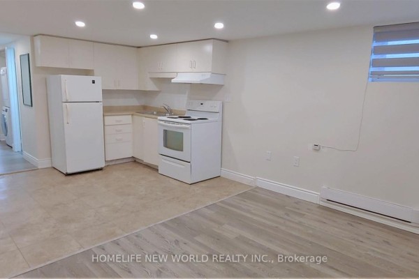 Basement unit with kitchen area, white appliances, and windows with blinds. - Bsmt - 158 Coxwell Avenue, Toronto