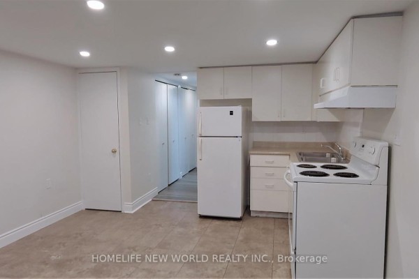 Basement apartment showing kitchen, refrigerator, stove, and a hallway with doors. - Bsmt - 158 Coxwell Avenue, Toronto