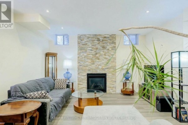 Living room with stone feature wall, fireplace, and modern furnishings - Bsmt - 161 Vanda Drive, Vaughan