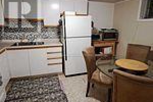 Compact kitchen with white cabinets, patterned backsplash, and dining area - Bsmt - 19 Sepia Drive, Toronto