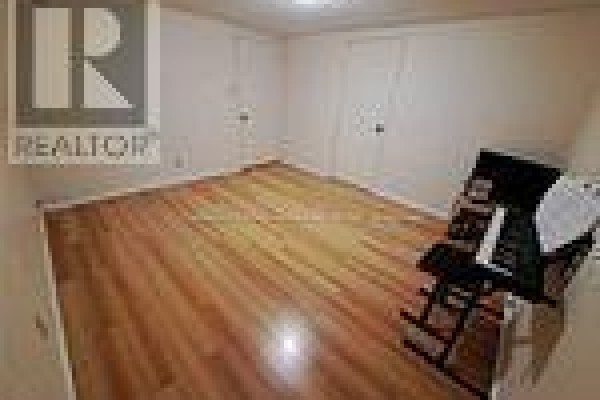 Empty room with hardwood flooring and neutral walls - Bsmt - 19 Sepia Drive, Toronto