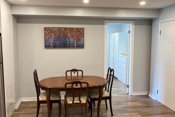 View of dining area and bedroom entrance, showing wood floors and light gray walls. - Bsmt - 21 Melbert Road, Toronto