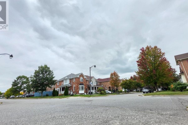 Exterior view of brick houses on a suburban street with trees. - Bsmt - 23 Wharnsby Drive, Toronto