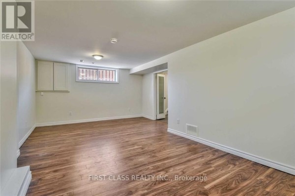 Spacious basement area with laminate flooring and two small windows. - Bsmt - 24 Fintona Avenue, Toronto