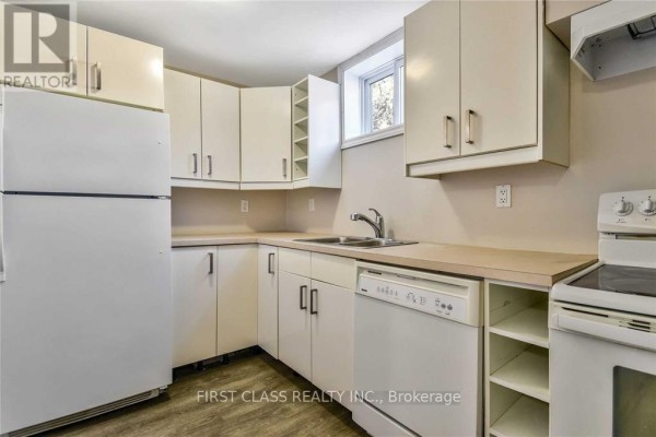 Open basement layout with a fireplace and natural light from a window. - Bsmt - 24 Fintona Avenue, Toronto